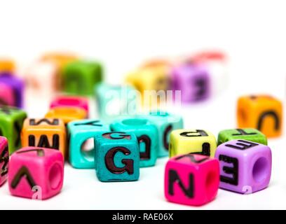 Tas de cubes multicolores jouet enfant avec des lettres sur fond blanc Banque D'Images