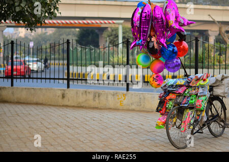 Vendeur de ballons's bike en stationnement sur trottoir transportant ballons colorés et des jouets à Delhi, Inde Banque D'Images