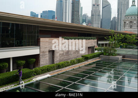 20.12.2018, Singapour, République de Singapour, en Asie - Un travailleur est le fraisage des couvertures sur le toit-terrasse de la Galerie nationale de Singapour. Banque D'Images