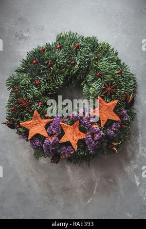 Couronne de Noël à la main à partir de matériaux naturels sur fond sombre Banque D'Images