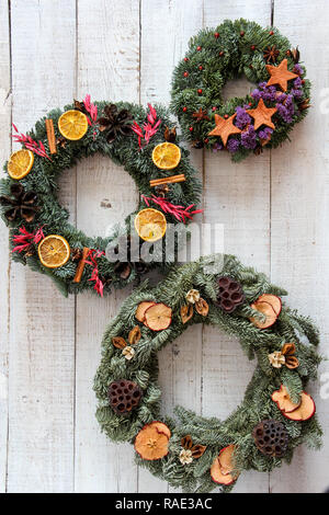 Des couronnes de Noël à la main à partir de matériaux naturels, sur un fond de bois blanc Banque D'Images