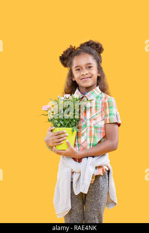 Cheerful ravi girl holding sa fleur préférée Banque D'Images