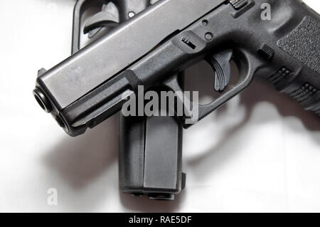 Deux pistolets semi-automatique noir, un 9mm et un calibre 40 avec l'une sur l'autre sur un fond blanc Banque D'Images