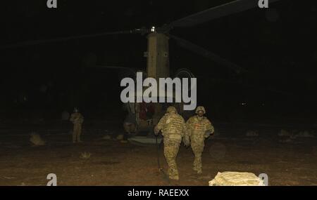 Les soldats de la Garde nationale d'armée de la Floride avec la Compagnie Alpha, 1er Bataillon, 111e Régiment d'aviation, ravitailler un hélicoptère d'attaque AH-64 Apache et UH-60 Blackhawk à partir d'un hélicoptère CH-47 Chinook juste à l'extérieur d'une zone hostile connu dans le sud-ouest de l'Asie le 30 janvier au cours d'un ravitaillement rapide, mission à long terme connu sous le nom de "grosse vache". Le CH-47 Chinook à distance peuvent faire le plein jusqu'à quatre oiseaux simultanément. Banque D'Images