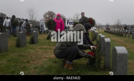 SUFFOLK en Virginie (déc. 15, 2018) Spécialiste des questions de personnel 1re classe Anna Willis (avant) place une couronne sur une tombe à l'Albert G. Horton Jr. Memorial Cimetière des anciens combattants au cours d'une cérémonie de dépôt. L'événement a été organisé par la société couronne de Horton depuis 11 ans de rendre hommage aux membres du service. Ceux avec les membres de la famille inhumés au cimetière ont la possibilité de déposer leurs couronnes en premier, suivi par les autres volontaires. Banque D'Images