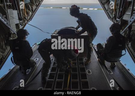 Royal Australian Air Force SGT Karl Penny, au centre à droite, et le SGT RAAF Jaime Polzin, centre gauche, à la fois 37e Escadron C-130J Super Hercules d'arrimeurs hors de la base de la RAAF de Richmond, l'Australie, préparer un paquet à bas coût reliés, être largués de l'atoll de Kapingamarangi, États fédérés de Micronésie, au cours de l'Opération Goutte de Noël 2018, 13 décembre 2018. À partir de la première d'airdrop Kapingamarangi il y a 67 ans, le TOC est le plus ancien de la mission de formation, la fourniture d'airdrop des fournitures essentielles à 56 îles micronésiennes et touchant environ 20 000 personnes sur 1,8 millio Banque D'Images