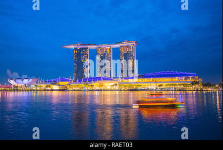 Vue paysage voyage Marina Bay en direction de l'ArtScience Museum et Marina Bay Sands Hotel de nuit, à Singapour Banque D'Images