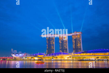 Vue paysage voyage Marina Bay en direction de l'ArtScience Museum et Marina Bay Sands Hotel de nuit, à Singapour Banque D'Images