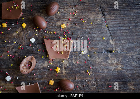 Composition de Pâques avec des œufs en chocolat et des morceaux de gros oeuf en chocolat sur fond de bois rustique ancienne avec place pour votre texte. Heureux Vacances de Pâques Banque D'Images