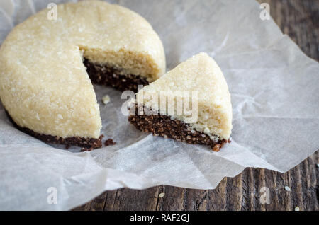 Des collations saines desserts sucrés. Super aliments diététiques de remise en forme. Halva sésame forme ronde avec chocolat et coco combiné sur la goulotte de remplissage vieille planche de bois, Banque D'Images