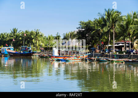 Les bateaux traditionnels sur la rivière Thu Bon et bordée de palmiers dans le vieux quartier de la ville historique. Hoi An, Quang Nam, Vietnam, Asie Banque D'Images