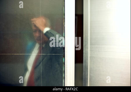 Senior businessman vu à travers la porte de verre, à la troublé. Banque D'Images