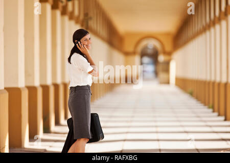Young businesswoman talking on cell phone in train station. Banque D'Images