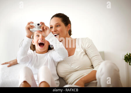 Mère et fille de prendre un autoportrait avec un appareil photo numérique. Banque D'Images