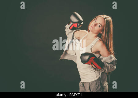 L'exercice de se préparer à se battre. L'esprit sportif et le corps solide. Femme énergique porter sportswear avec des épaules avec boxe adversaire. Sport et fi Banque D'Images