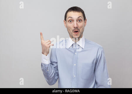 J'ai une idée. Portrait of happy surpris handsome businessman in bristle classique bleu shirt debout avec doigt vers le haut et à la caméra à l'intérieur. s Banque D'Images