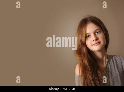 Brune aux yeux bleus jeune fille timide aux longs cheveux Banque D'Images