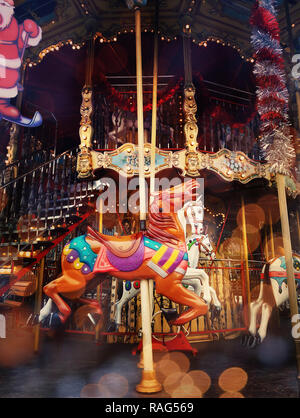 Lumineux magnifique carrousel en parc d'enfants la nuit en hiver. Close up des silhouettes de chevaux avec des décorations de Noël vintage, gl Banque D'Images