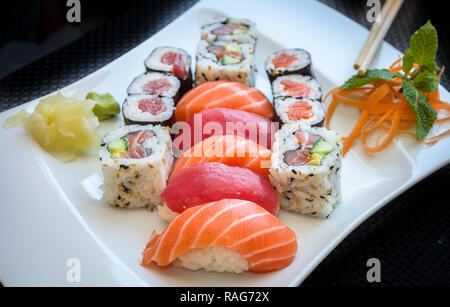 Sushi maki et California Roll avec du gingembre et wasabi sur une plaque avec des baguettes. Banque D'Images