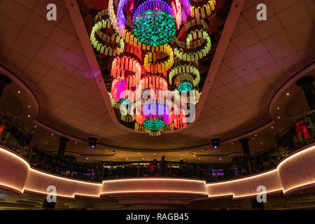 Un grand appareil d'éclairage coloré dans l'atrium du bateau de croisière Norwegian Jade. Banque D'Images