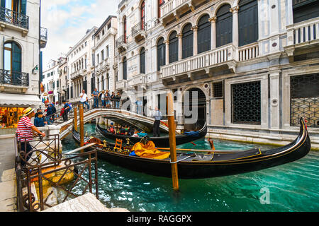 Une longue section de canal à la calle de la Canonica en touristes traversent le pont sur une gondole et gondolier attend les clients à Venise, Italie Banque D'Images