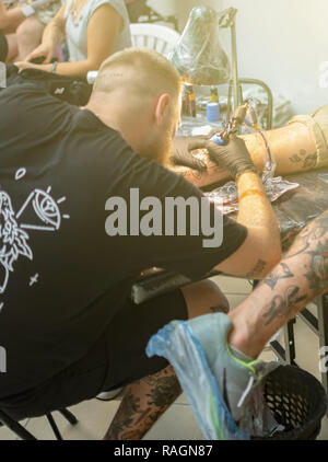 Tatoueur fait un tatouage sur la main d'un homme. Banque D'Images