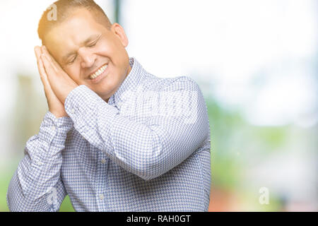 L'âge moyen d'affaires arabes sur fond isolé homme fatigué dormir rêver et posant avec les mains tout en souriant avec les yeux fermés. Banque D'Images