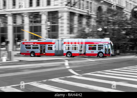 Le panoramique de la caméra d'un déménagement trolleybus à Market Street à San Francisco, États-Unis, avec fond noir et blanc. Banque D'Images