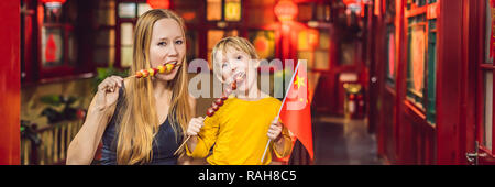 Profiter de vacances en Chine. Heureux touristes maman et son fils avec un drapeau chinois et chinois traditionnel avec des fruits confits sur un arrière-plan chinois. Voyage en Chine avec les enfants la notion. Visa de transit de 72 heures, 144 heures en Chine BANNER, format long Banque D'Images
