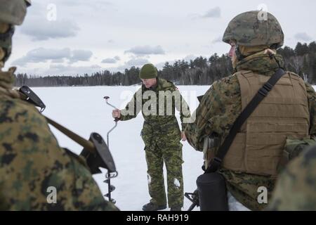 Le capitaine Craig Hannon, un instructeur de la guerre en montagne avec 2e Bataillon du Régiment Irlandais du Canada, porte sur les activités de pêche sur glace à marines avec la société C, 1er Bataillon, 25e Régiment de Marines, 4e Division de marines, pendant l'exercice Riley Xanten II, dans la région de Burwash, Ontario, 3-5 février, 2017. Au cours de l'exercice, les Marines s'est joint à des soldats de l'Armée canadienne à l'échange de connaissances et d'accroître la compétence dans le temps froid, les tactiques de survie, l'abri, bâtiment de pêche sur glace, et plus encore. Banque D'Images