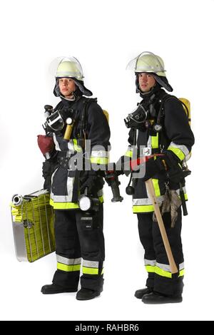 Pompiers, partie d'une équipe d'intervention pour la lutte contre les incendies, de vêtements de protection en Nomex, un casque avec une visière, une hache d'incendie, Banque D'Images