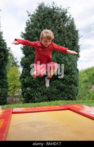Petit garçon sautant sur un trampoline, parc Serengeti, Hodenhagen, Basse-Saxe Banque D'Images