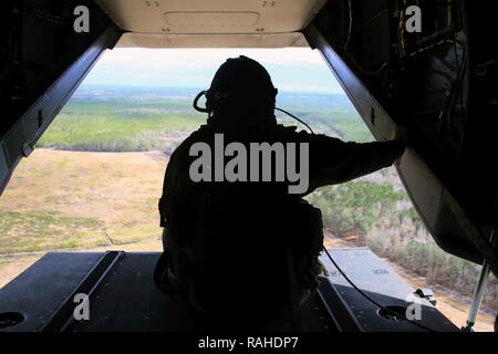 Le Sgt. Brett Hankins regarde à l'arrière d'un MV-22 Osprey comme il vole près de Marine Corps Air Station New River, N.C., 9 février 2017. De nombreuses opérations sont intensifs sur Osprey pilotes comme ravitaillement en vol, mais certaines opérations de vol tels que les ascenseurs exigent les pilotes à s'appuyer sur le chef de l'équipe. De ce fait, ils sont un élément essentiel à la réalisation de la mission. Hankins est un chef de l'équipe de l'escadron 263 à rotors basculants Support Marine, Marine Aircraft Group 26, 2nd Marine Aircraft Wing. Banque D'Images