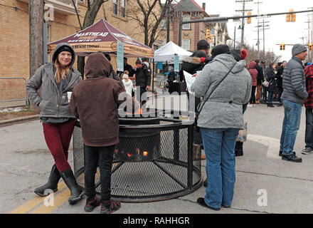 Les visiteurs de la 3ème Conférence annuelle Gordon Square Wintertide Festival de rester au chaud autour d'un feu de camp en plein air dans la région de Cleveland, Ohio, USA. Banque D'Images