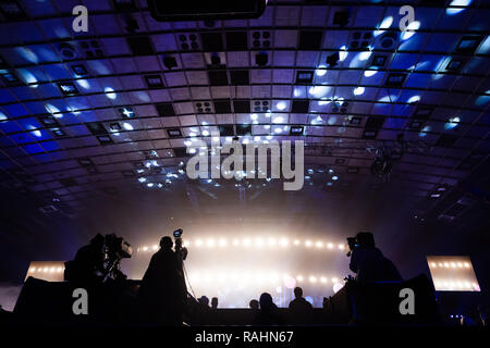 Un groupe de travail de cameramen pendant le concert. Nombre d'événement. Silhouettes d'ouvriers contre l'arrière-plan de faisceaux colorés. Banque D'Images