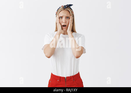 Beau jeune femme blonde essayé faire cake se sentir triste et sombre il a ruiné, fronçant holding paumes sur le visage et le regard de désespoir et de tristesse à l'appareil photo, d'être très déçu Banque D'Images