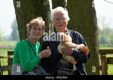 La tenue d'un couple de personnes âgées du poulet dans un zoo ou ferme pour enfants, Wilhelmsburg, Hambourg Banque D'Images