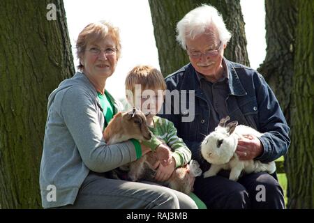 Couple de personnes âgées avec leur petit-enfant à une ferme pour enfants ou zoo, Wilhelmsburg, Hambourg Banque D'Images