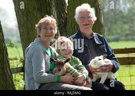 Couple de personnes âgées avec leur petit-enfant à une ferme pour enfants ou zoo, Wilhelmsburg, Hambourg Banque D'Images