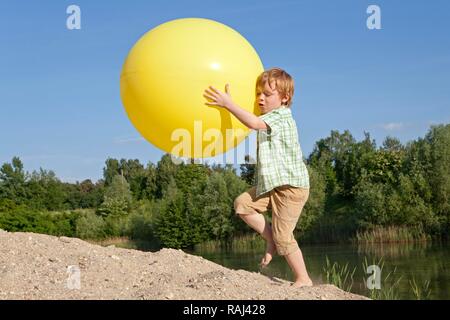 Petit Garçon jouant avec un gros ballon Banque D'Images