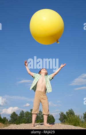 Petit Garçon jouant avec un gros ballon Banque D'Images