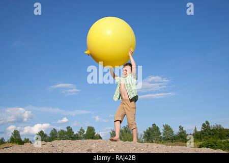 Petit Garçon jouant avec un gros ballon Banque D'Images