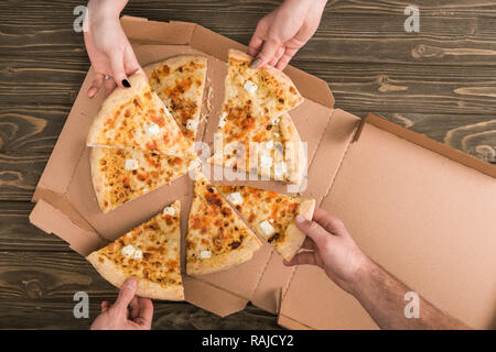 Portrait d'amis manger du fromage La pizza sur la table en bois Banque D'Images