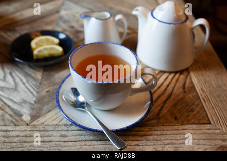 Thé Earl Grey servi avec des morceaux de citron. Le thé est servi dans une théière. Banque D'Images