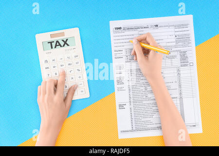 Portrait de femme à l'aide de la calculatrice mot "taxe" et remplir le formulaire d'impôt sur fond jaune et bleu Banque D'Images