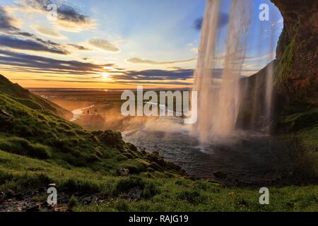 Seljalandsfoss au coucher du soleil, à côté de deux personnes, des silhouettes à la séance photo, Suðurland, Sudurland, près de ring road Banque D'Images