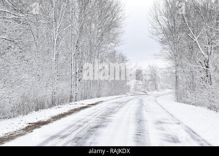 Route de campagne enneigée avec Snowy qui bordent les deux côtés de la route calme et tranquille Banque D'Images