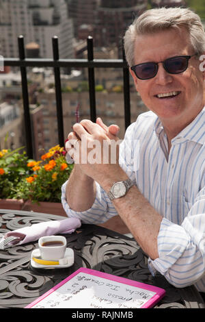 Homme mature jouit d'espresso à un restaurant sur le toit, à New York City, USA Banque D'Images