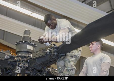 La CPS. Ainsworth L., Carridice et SPC. Jose Castaneda avec Société Delta 1er Bataillon, 3e Régiment d'aviation d'attaque (Reconnaissance) phase de conduite d'entretien sur un hélicoptère AH-64 Apache à Katterbach Army Airfield, Allemagne, le 10 février 2017. Les inspections de maintenance phase se produire à intervalles réguliers sur tous les aéronefs afin de les maintenir opérationnels. Banque D'Images