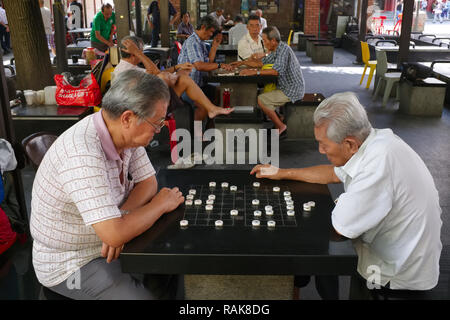 Les hommes d'origine chinoise à Kreta Ayer Square, Chinatown, Singapour, derrière le Temple de la dent de Bouddha, de variations de jeu d'échecs chinois ou Mahjong Banque D'Images